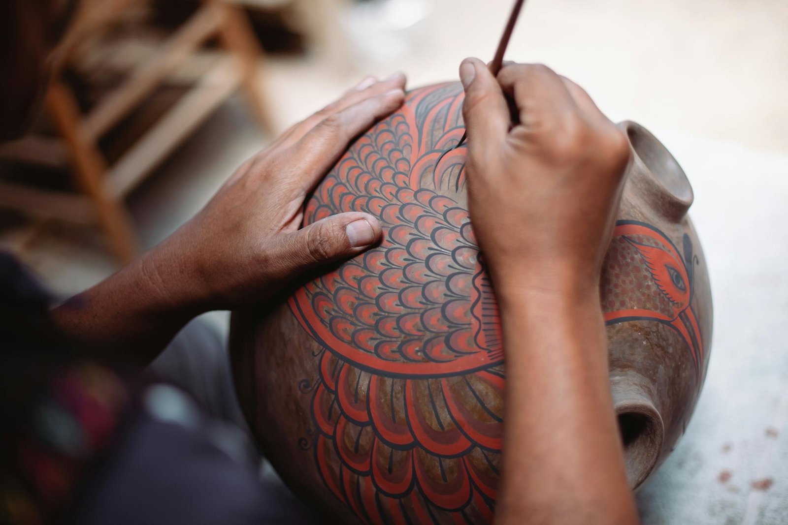 Craftsman hand-painting a Kalasha vessel — symbol of abundance